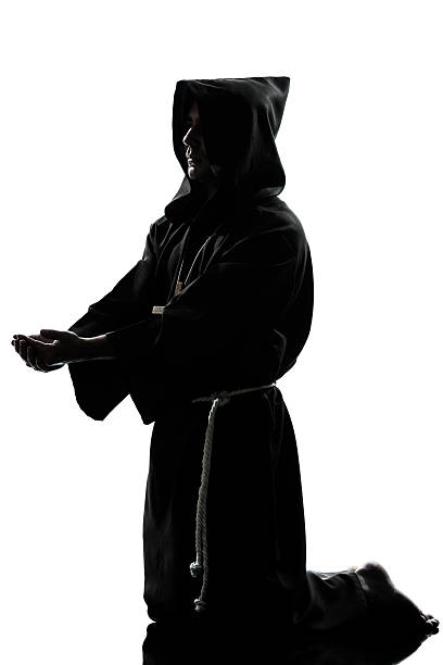 istock man monk priest silhouette praying 185679542