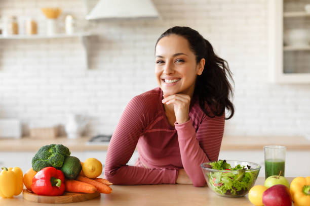 Happy Young Woman In Fitwear Posing At Table In Kitchen
