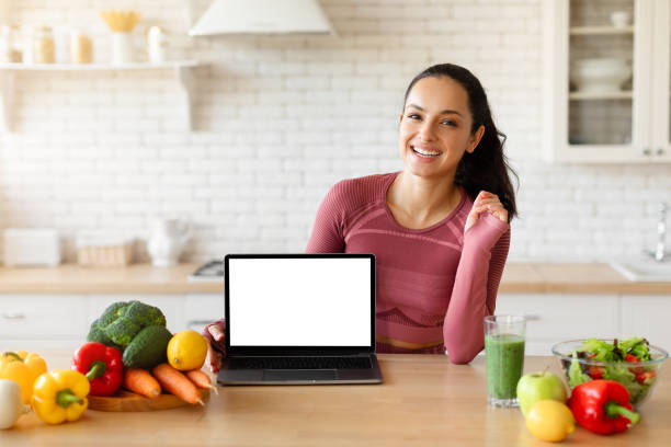 istock Cheerful lady showing laptop blank white screen in home kitchen 1856848925