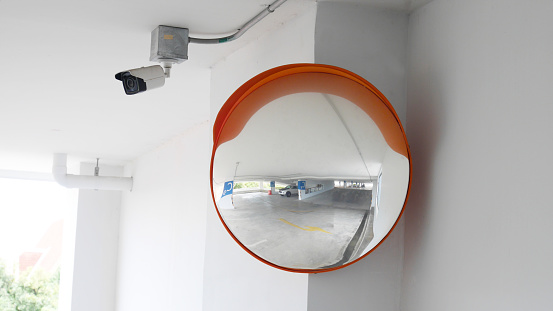 The curved glass with securit camera is installed at the corner of the parking building to prevent accidents from driving in the opposite direction