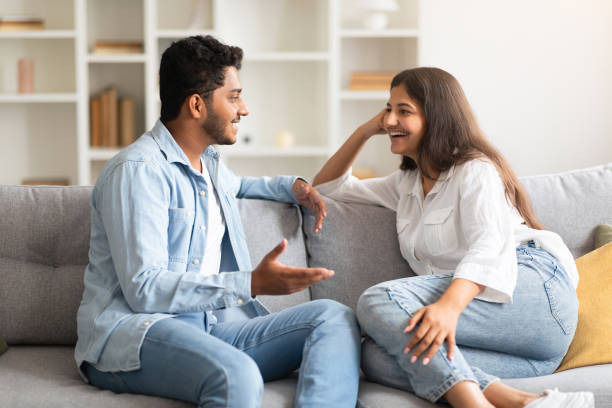 istock Young loving indian couple talking and flirting enjoying conversation at home, spending time together sitting on sofa 1856863033