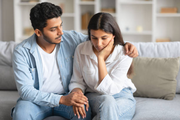 istock Caring indian husband soothing his distressed wife on sofa 1856863063