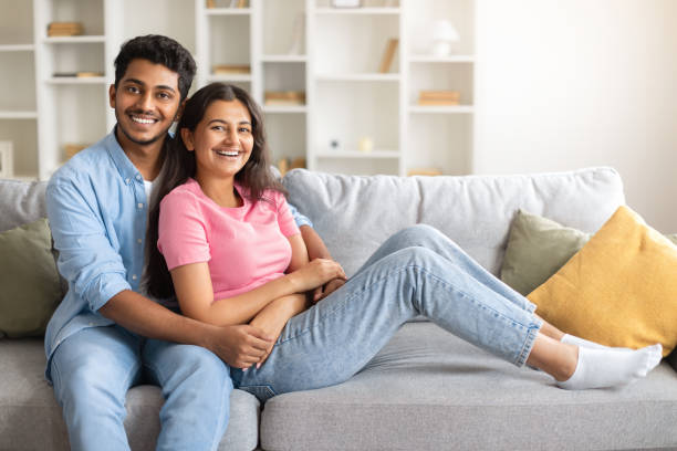 istock Joyful indian couple embracing and smiling at camera at home, free space 1856863067