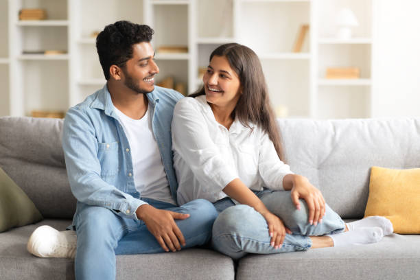 istock Excited Indian spouses laughing and relaxing on a sofa 1856863611