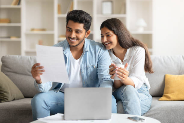 istock Happy Indian couple reviewing a document with a laptop 1856863613