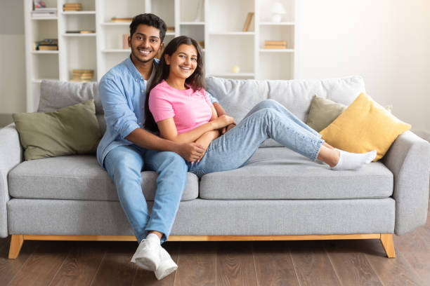 istock Happy Indian spouses embracing on sofa, smiling at camera 1856863617