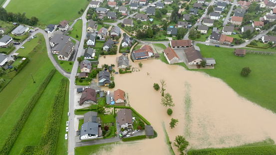 Aerial view of flood water surrounded residential buildings and land.