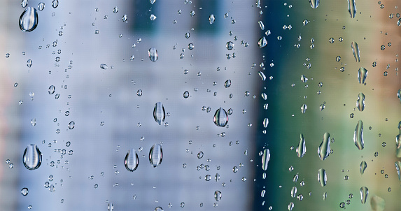 Close-up of water drops on transparent glass window.