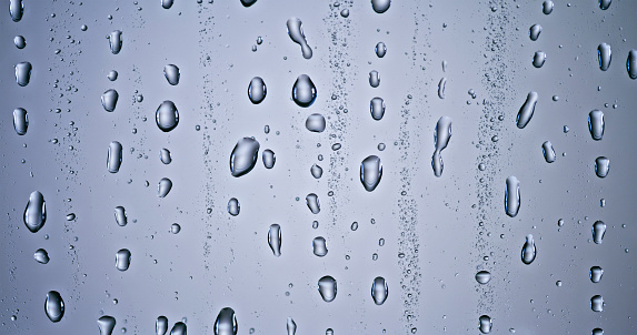 Close-up of water drops on transparent glass window.