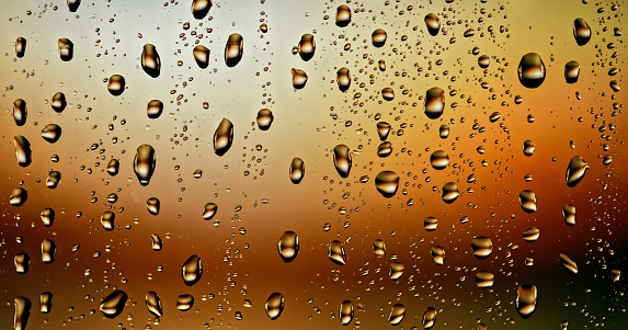 Close-up of water drops on transparent glass window.