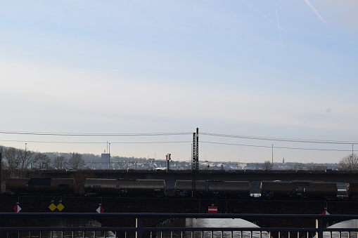 Koblenz, Germany - 12/07/2023: dark freight train on a bridge next tot the road bridge