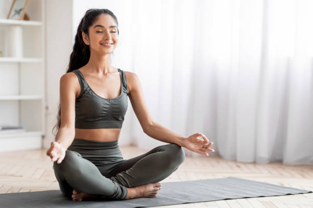 istock Peaceful young eastern woman meditating at home 1856879951