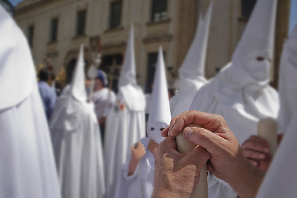 Detail penitent white holding a candle during Holy Week, Palm Sunday, Sevilla, Andalusia, Spain