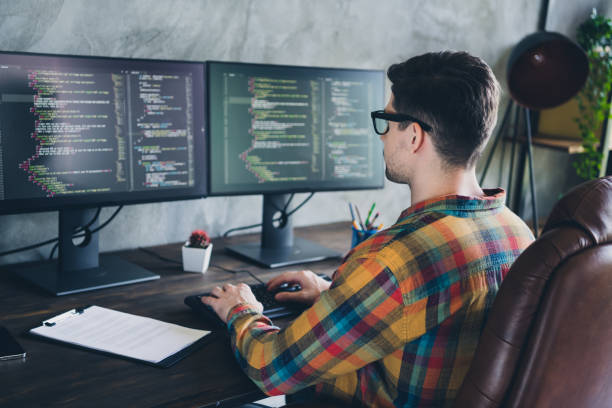 istock Rear back view photo of remote worker man focused on creating perfect data analysis automatic bot code sitting armchair at home office 1856887885