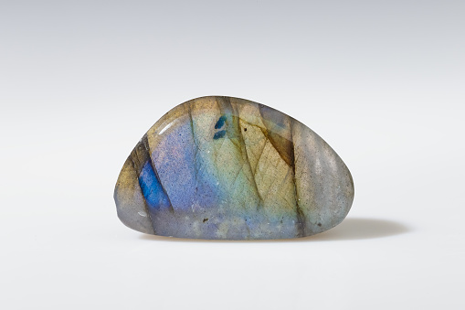 Polished Labradorite Mineral Gem Stone with Blue and Yellow Iridescence on Grey Background