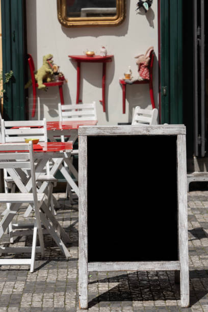 blank menu chalkboard over tables and chairs in cafe stock photo