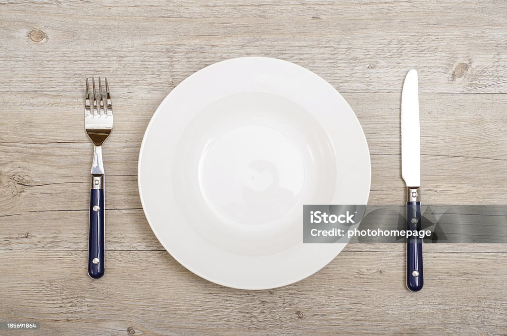 Blue knife and fork with white plate Blue knife and fork with white plate on  a dinner table Blue Stock Photo