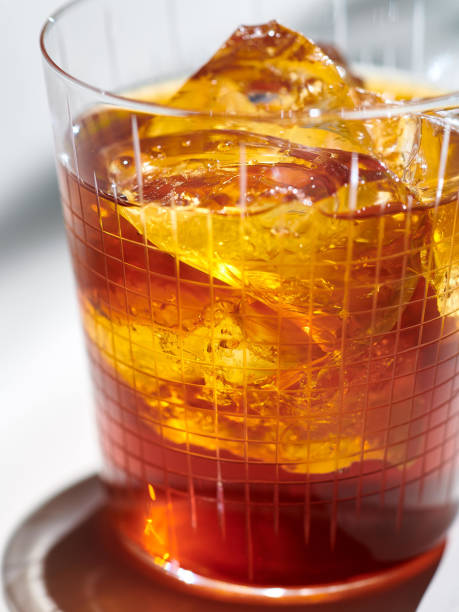 istock Cold brew coffee shot indoors, textured glass refracts light, sun dappled shadow background 1856923454