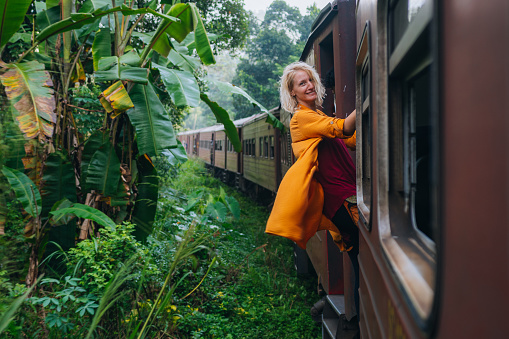 Tourist female enjoys a famous scenic train ride through Sri Lanka.