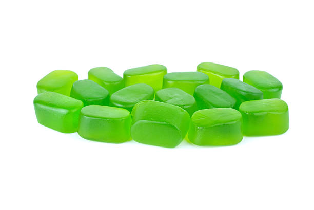 Few green fruit jellies over the white background