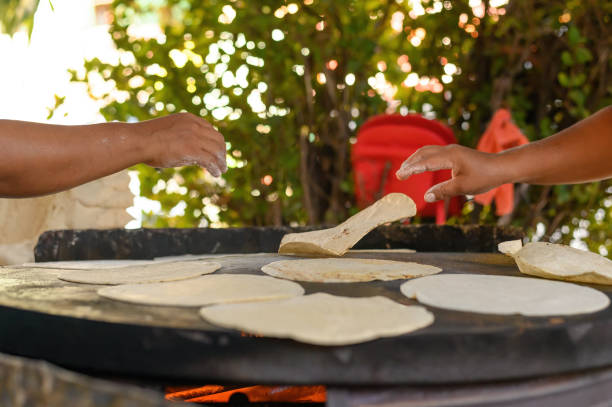 istock Anonymous cooks frying Mexican flatbreads in nature 1856996719