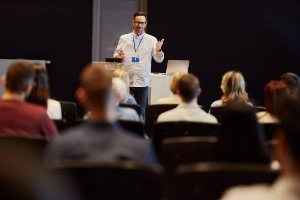 istock Happy public speaker talking on a conference at convention center. 1857041893