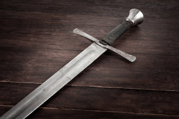 istock Medieval sword on wooden background. 1857054505