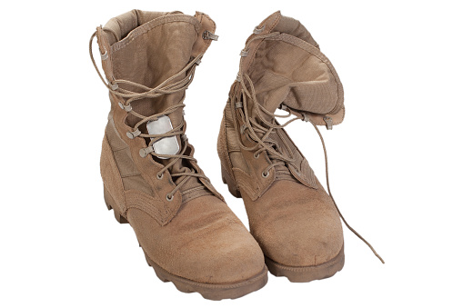 US Army combat desert boots with dog tags isolated on white background