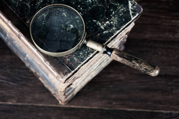 istock Vintage magnifying glass with books on table 1857061664