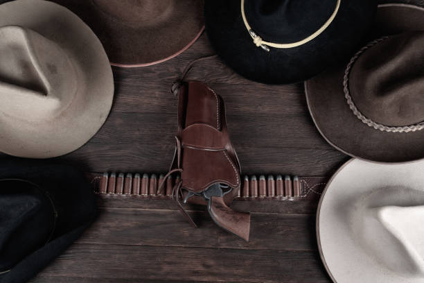 istock Gun with holster and gun belt with old west hats on table. Top view. 1857063818
