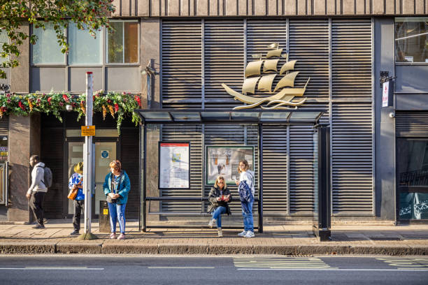 Woburn Place, London, England - October 31th 2023:  People waiting for the bus in the morning sunlight