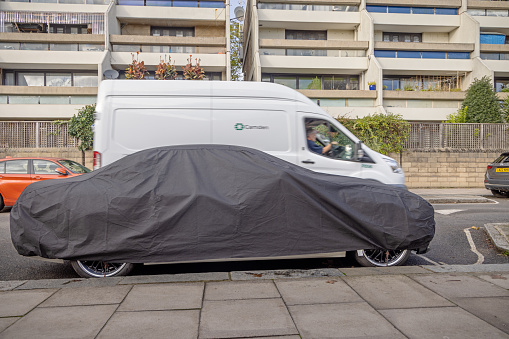 Raydon Street, Highgate, London, England - October 31th 2023:  Car under a black tarpaulin in a residential area in a suburb to London