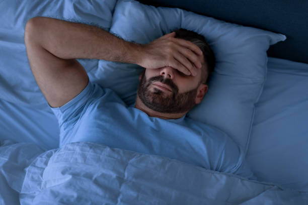 istock Man Covering Face With Hand Lying Not Sleeping In Bedroom 1857087042