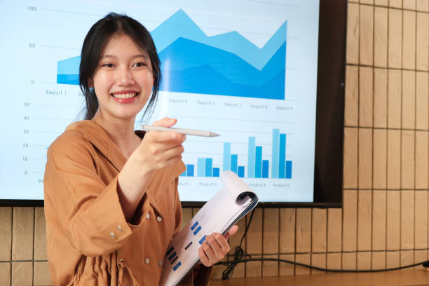 istock Young asian businesswoman presenting data analysis dashboard on TV screen in modern meeting 1857087431