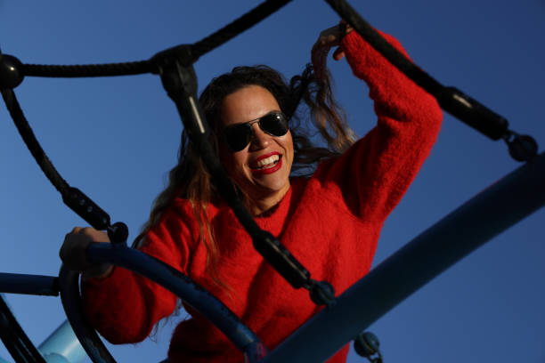 Young girl smiling and having fun outdoors on a bright playground slide