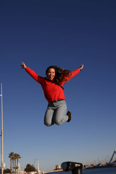 istock Young active lady jumping at waterside during blue hour 1857108629