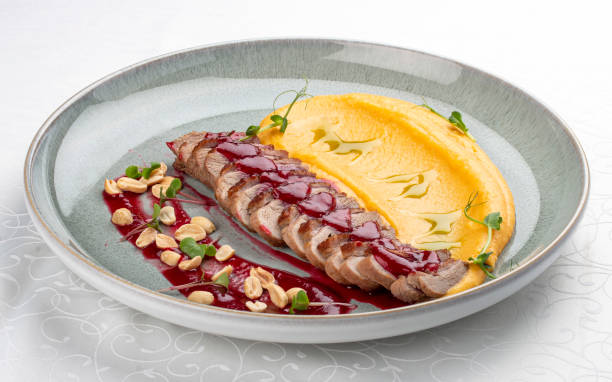 istock Duck breast, with pumpkin puree, cherry sauce and peanuts. Isolated image 1857112572