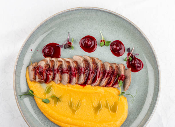 Duck breast, with pumpkin puree, cherry sauce and peanuts. Isolated image