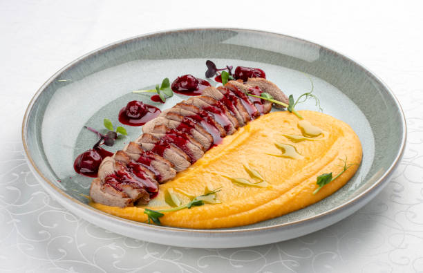 istock Duck breast, with pumpkin puree, cherry sauce and peanuts. Isolated image 1857113090