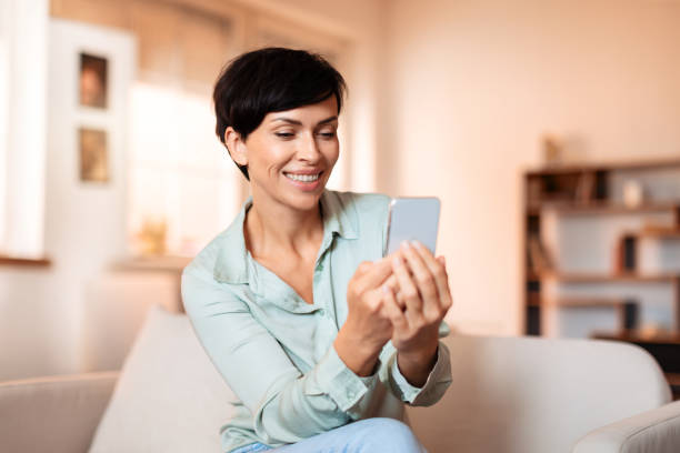 istock Brunette woman casually texting on her mobile phone at home 1857117414