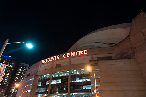 Rogers Centre, home of the Toronto Blue Jays, at the base of the CN Tower in Toronto, Ontario, Canada on a clear Autumn night with a cloudless sky.