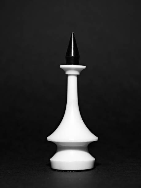 White chess piece on a black background. Black and white photo.
