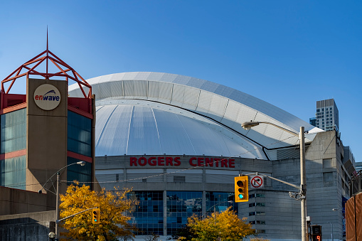 Rogers Centre, home of the Toronto Blue Jays, at the base of the CN Tower in Toronto, Ontario, Canada on a bright Autumn day with a cloudless sky.