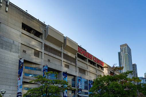 Rogers Centre, home of the Toronto Blue Jays, at the base of the CN Tower in Toronto, Ontario, Canada on a bright Autumn day with a cloudless sky.