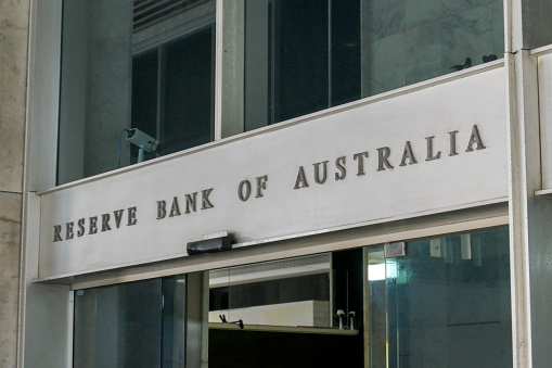 The main pedestrian entrance of the Reserve Bank of Australia building at 65 Martin Place in the central business district of Sydney.  The automatic glass doors are briefly open.  This image was taken from outside the building, looking through the glass facade, on a sunny afternoon on 15 December 2023.