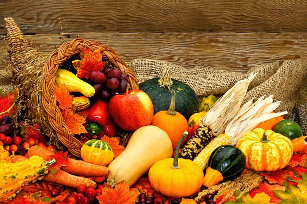 Cornucopia of autumn vegetables with wood background Harvest or Thanksgiving cornucopia filled with vegetables against wood background cornucopia stock pictures, royalty-free photos & images