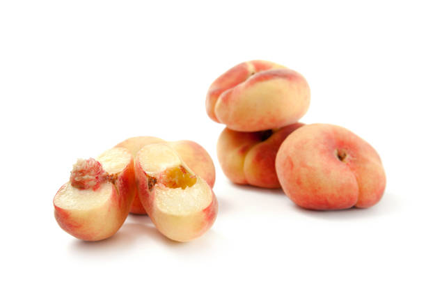 istock Half and several whole saturn peaches or flat peaches isolated on white background with clipping path. 1857190764