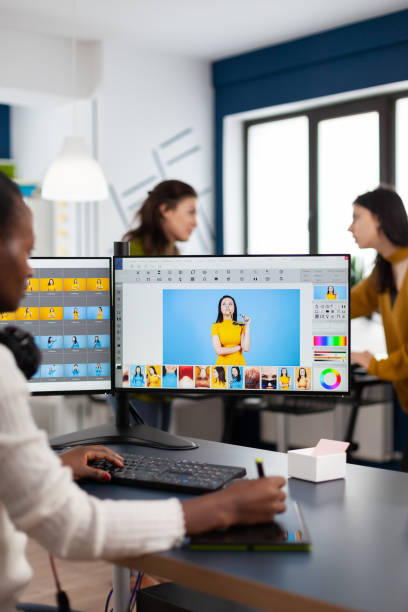 istock Black retoucher woman analysing images on computer with two monitors 1857190768