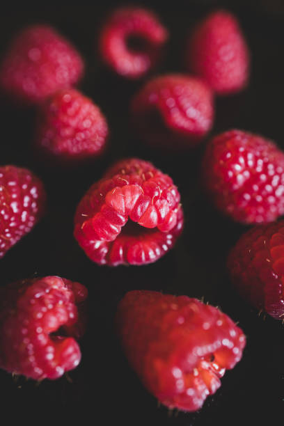 Delicious, ripe and juicy raspberries on a black background