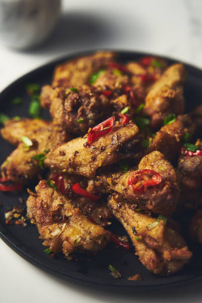 istock Chinese Salt and Pepper chicken wings. Crispy battered Deep fried chicken wings with vegetables seasoned with salt and pepper and then quickly sauteed with onions, garlic and chilies. 1857197660